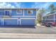 Two-story townhouse with blue exterior, garages, and well-maintained landscaping at 1287 S Wheeling Way, Aurora, CO 80012