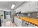 Bright kitchen features butcher block countertops, stainless steel appliances, and an open layout to dining area at 1287 S Wheeling Way, Aurora, CO 80012
