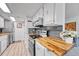 Well-lit kitchen features white cabinets, wood countertops, gray backsplash, and stainless steel appliances at 1287 S Wheeling Way, Aurora, CO 80012