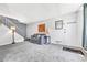 Comfortable living room with soft gray sofa, plush carpeting, and a staircase, showcasing modern decor and a welcoming entrance at 1287 S Wheeling Way, Aurora, CO 80012
