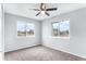 Cozy carpeted bedroom with a ceiling fan and street view windows at 206 Cedar St, Hudson, CO 80642