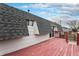 View of the red painted wooden deck, siding, and roof of the property at 206 Cedar St, Hudson, CO 80642