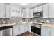 Well-appointed kitchen with stainless steel appliances, butcher block countertops, mosaic backsplash and updated lighting at 206 Cedar St, Hudson, CO 80642