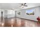Expansive living room featuring wood flooring, ceiling fans, bright windows with views, and adjacent dining area at 206 Cedar St, Hudson, CO 80642