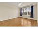 Cozy bedroom featuring hardwood floors and large window with navy curtains at 8915 Federal Blvd # 104, Westminster, CO 80260