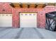 Exterior view of tan garage doors with decorative windows on a brick home at 8915 Federal Blvd # 104, Westminster, CO 80260