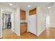 Galley kitchen with white refrigerator, ample wood cabinetry and wood flooring at 8915 Federal Blvd # 104, Westminster, CO 80260