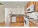 Bright kitchen featuring wood cabinets, white appliances and wood flooring at 8915 Federal Blvd # 104, Westminster, CO 80260