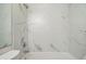 Bright bathroom featuring a shower-tub combo and white marble-style tile surround at 1211 W 112Th Ave # B, Denver, CO 80234