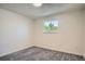 Bright bedroom features neutral paint, new carpet, and a window overlooking greenery at 1211 W 112Th Ave # B, Denver, CO 80234