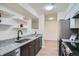 Galley kitchen features granite countertops, stainless steel appliances, and decorative floating shelves at 1211 W 112Th Ave # B, Denver, CO 80234