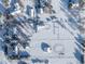 Aerial view of snow-covered homes and outbuildings with mature trees and snow covered fields at 8530 W Jefferson Ave, Denver, CO 80235