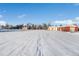 Snow-covered barn with a path leading to a series of buildings and fields beyond at 8530 W Jefferson Ave, Denver, CO 80235