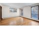 A bright bedroom with hardwood flooring features views of snowy trees through large windows at 8530 W Jefferson Ave, Denver, CO 80235