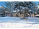 Charming brick home exterior with a snow-covered yard and mature trees at 8530 W Jefferson Ave, Denver, CO 80235