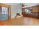 Inviting living room featuring hardwood floors, a brick fireplace, and ample natural light from the large window at 8530 W Jefferson Ave, Denver, CO 80235