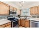 Bright kitchen featuring wood cabinets, stainless steel appliances, and mosaic tile backsplash at 5750 W Atlantic Pl, Lakewood, CO 80227