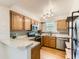 Well-lit kitchen featuring wood cabinets, stainless steel appliances, and ample countertop space at 5750 W Atlantic Pl, Lakewood, CO 80227
