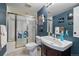 Cozy bathroom featuring a glass shower, modern sink, and beautiful blue wall at 6251 S Iola Ct, Englewood, CO 80111