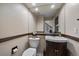 Well-appointed half bathroom featuring a dark wood vanity, updated fixtures, and a decorative mirror at 6251 S Iola Ct, Englewood, CO 80111