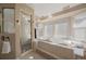 Bright bathroom with a soaking tub, glass shower, and lots of natural light from bay windows at 6251 S Iola Ct, Englewood, CO 80111