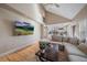 Open concept living area flowing into the kitchen, featuring hardwood floors, neutral tones, and a large TV at 6251 S Iola Ct, Englewood, CO 80111