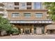 Elegant building entrance featuring stone facade, modern glass doors, and manicured landscaping at 5455 Landmark Pl # 1009, Greenwood Village, CO 80111