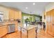 Open concept kitchen with wood cabinets, granite countertops, island, and stainless steel dishwasher at 3644 Sunchase Dr, Castle Rock, CO 80109