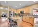 Kitchen with light wood cabinets, granite counters, stainless steel fridge, and island with seating at 3644 Sunchase Dr, Castle Rock, CO 80109