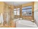 Luxurious main bathroom with a standalone shower, soaking tub, tiled floors, and a bright window at 3644 Sunchase Dr, Castle Rock, CO 80109