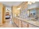 Spacious main bathroom featuring double sinks, granite countertops, stone accent wall, and access to main bedroom at 3644 Sunchase Dr, Castle Rock, CO 80109