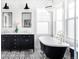 Luxurious bathroom featuring a soaking tub, double vanity, and elegant black-and-white tile flooring at 11745 Newton St, Westminster, CO 80031