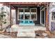 Cozy covered patio featuring a comfortable daybed swing with plush pillows and elegant stone flooring at 11745 Newton St, Westminster, CO 80031