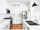 Modern white kitchen featuring stainless steel appliances, quartz countertops and tiled backsplash at 11745 Newton St, Westminster, CO 80031