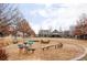 Community playground with unique play structures, wood chips, seating, and nearby homes at 11745 Newton St, Westminster, CO 80031