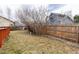 A spacious backyard with grass and a wooden fence bordering neighboring homes creating a private outdoor space at 19634 E Clear Creek Trl, Parker, CO 80134