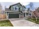 Inviting two-story home showcasing green siding, stone accents, a two-car garage, and a well-maintained front yard at 19634 E Clear Creek Trl, Parker, CO 80134