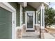 Close-up of front entrance with stone accents, green siding, and a well-lit porch at 19634 E Clear Creek Trl, Parker, CO 80134