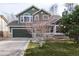 Charming two-story home with green siding, stone accents, a two-car garage, and a well-maintained front lawn at 19634 E Clear Creek Trl, Parker, CO 80134