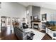 Open-concept living room featuring a stone fireplace, vaulted ceilings, large windows, and views into the dining area at 19634 E Clear Creek Trl, Parker, CO 80134