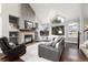 Bright living room with vaulted ceilings, stone fireplace, large windows, and comfortable leather seating at 19634 E Clear Creek Trl, Parker, CO 80134