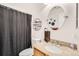 This bathroom features a toilet, mirror, and sink with granite countertops, with a dark gray shower curtain at 15685 E 50Th Ave, Denver, CO 80239