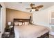 The cozy bedroom includes a leaf-design ceiling fan, two side tables, and a comfortable queen-sized bed at 15685 E 50Th Ave, Denver, CO 80239