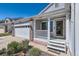 Inviting front porch of this home with white pillars, brick accents, and a well-manicured landscape at 15685 E 50Th Ave, Denver, CO 80239