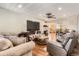 Cozy living room with plush seating, wood floors, a ceiling fan, and an open view to the dining area at 15685 E 50Th Ave, Denver, CO 80239