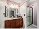 Well-lit bathroom with a wooden vanity, granite countertop, and a glass-enclosed shower at 1572 W Long Ave, Littleton, CO 80120