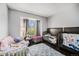 Bright bedroom with hardwood floors features two cribs and window with natural light at 1572 W Long Ave, Littleton, CO 80120