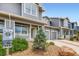Street view of a gray townhome featuring a front porch, landscaped yard, and attached one-car garage at 226 Ash St, Bennett, CO 80102