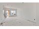 Spacious living room with white walls, windows, and unfinished floors during construction at 226 Ash St, Bennett, CO 80102