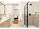 Bathroom featuring a sink, shower with glass enclosure, and doorway that leads to bedroom at 2939 Osceola St, Denver, CO 80212